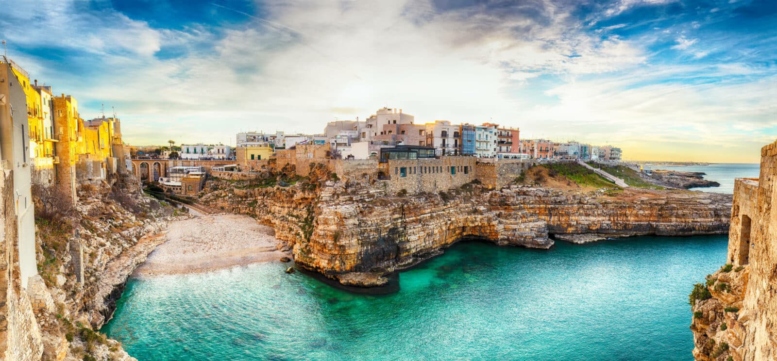 Sunset at Cala Paura gulf with Bastione di Santo Stefano and Lama Monachile beach in background. Polignano a Mare, Apulia, Italy, province of Bari.